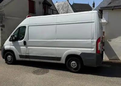 Camionnette blanche garée dans une rue résidentielle