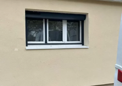 Fenêtre avec volet roulant sur mur beige