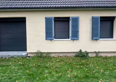 Maison avec volets bleus et pelouse verte